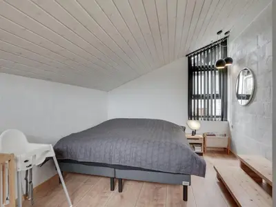 a bedroom with a bed and a desk and a chair at Holiday Home Kadife - 750m from the sea by Interhome in Saltum