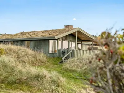 a house sitting on top of a grassy hill at Holiday Home Fransine - 480m from the sea by Interhome in Saltum