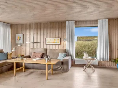 a living room with a couch and a table at Holiday Home Fransine - 480m from the sea by Interhome in Saltum