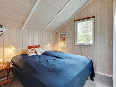 a bedroom with a large blue bed in a room at Holiday Home Varpu - 1-6km from the sea by Interhome in Saltum