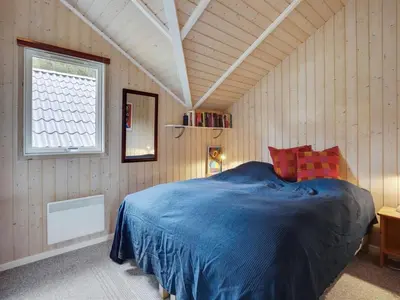 a bedroom with a blue bed in a room at Holiday Home Varpu - 1-6km from the sea by Interhome in Saltum