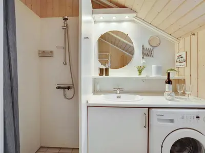 a bathroom with a washing machine and a sink at Holiday Home Varpu - 1-6km from the sea by Interhome in Saltum