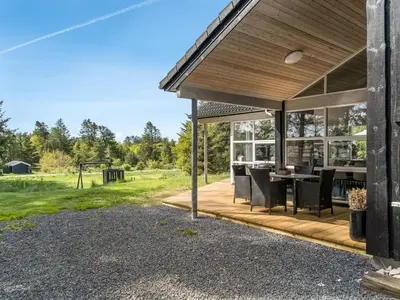 an outdoor patio with a table and chairs at Holiday Home Nayati - 2km from the sea by Interhome in Saltum