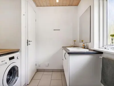 a white laundry room with a sink and a washing machine at Holiday Home Swen - 1-3km from the sea by Interhome in Saltum