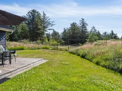 a patio with a table and chairs in a yard at Holiday Home Swen - 1-3km from the sea by Interhome in Saltum