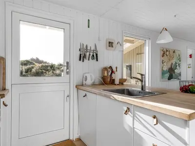 a white kitchen with a sink and a window at Holiday Home Asser - 400m from the sea by Interhome in Saltum