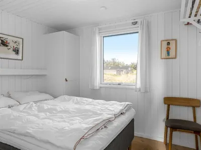a white bedroom with a bed and a window at Holiday Home Asser - 400m from the sea by Interhome in Saltum
