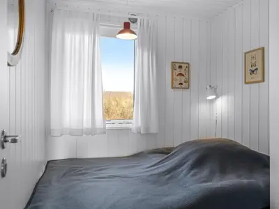 a bedroom with a bed and a window at Holiday Home Asser - 400m from the sea by Interhome in Saltum