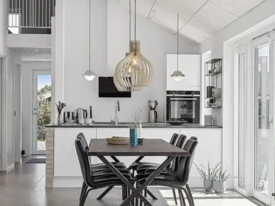 a kitchen with a wooden table and black chairs at Holiday Home Fredrika - 1-5km from the sea by Interhome in Saltum