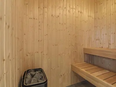 a wooden sauna with a trash can in it at Holiday Home Fredrika - 1-5km from the sea by Interhome in Saltum