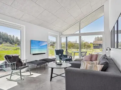a living room with a couch and chairs and a table at Holiday Home Fredrika - 1-5km from the sea by Interhome in Saltum