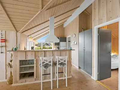 a kitchen with a counter and stools in a room at Holiday Home Sochyeta - 150m from the sea by Interhome in Harboør