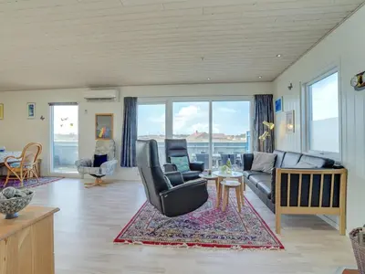 a living room with a couch and a table at Holiday Home Soyala - 400m from the sea by Interhome in Harboør