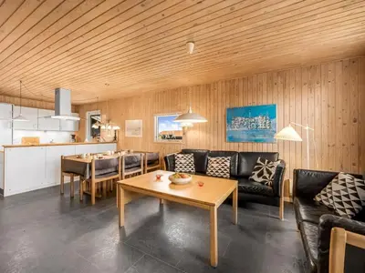 a living room with a couch and a table at Holiday Home Odmar - 300m from the sea by Interhome in Harboør