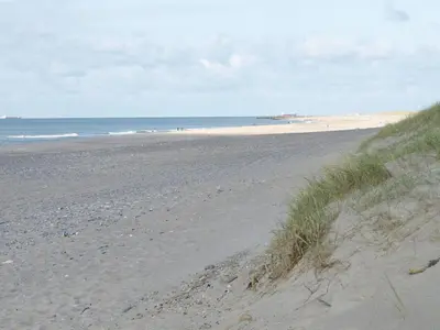 a sandy beach with the ocean in the background at Holiday Home Ernbiorn - from the sea by Interhome in Harboør