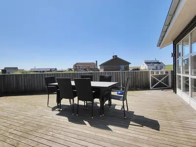 a dining table and chairs on a deck at Holiday Home Ernbiorn - from the sea by Interhome in Harboør