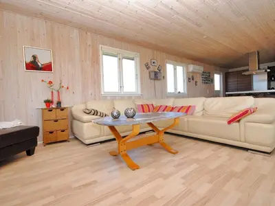 a living room with two couches and a table at Holiday Home Ernbiorn - from the sea by Interhome in Harboør