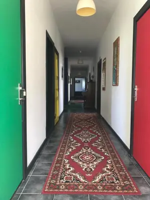 a corridor with colorful doors and a rug on the floor at La Ola in Hanstholm