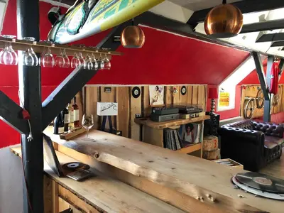 a bar in a room with a surfboard on the wall at La Ola in Hanstholm