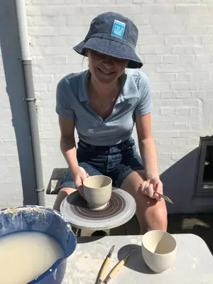a woman in a hat is making a bowl on aucer at La Ola in Hanstholm