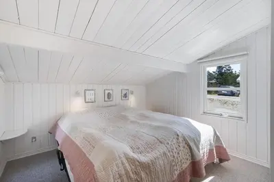 a bedroom with a large bed in a white room at Cozy Holiday Home in Lovely Surroundings in Sønder Vorupør