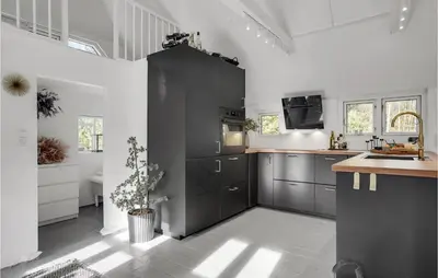 a kitchen with black cabinets and a sink at Amazing Home In Pandrup in Pandrup