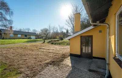 a yellow building with a door next to a dirt road at 3 Bedroom Awesome Home In Thisted in Thisted