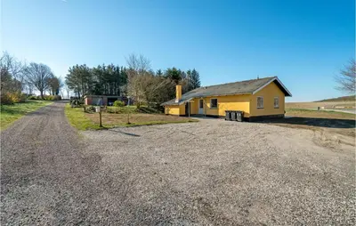 a small yellow house on the side of a gravel road at 3 Bedroom Awesome Home In Thisted in Thisted