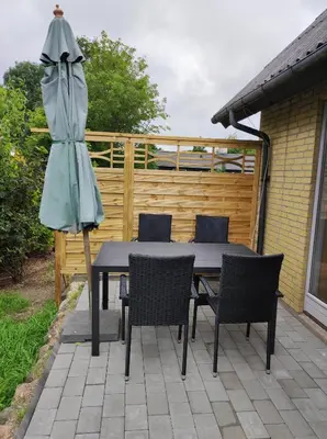a table and chairs with an umbrella on a patio at Hjortdal B&B in Fjerritslev