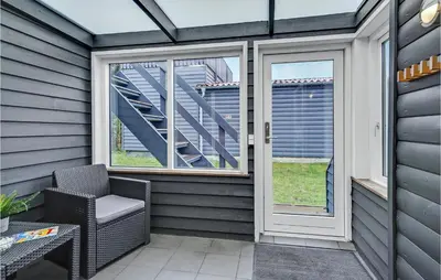 a screened in porch with a chair and a staircase at 2 Bedroom Stunning Home In Hanstholm in Hanstholm