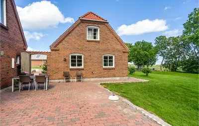 a brick house with a table and chairs on a brick patio at 3 Bedroom Cozy Home In Vesløs in Vesløs