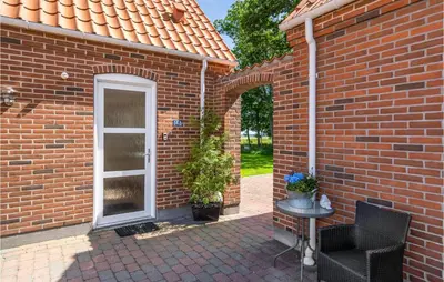 a brick house with a white door and a patio at 3 Bedroom Cozy Home In Vesløs in Vesløs