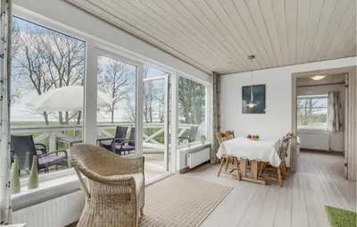 a room with a table and chairs and windows at 3 Bedroom Cozy Home In Vesløs in Vesløs