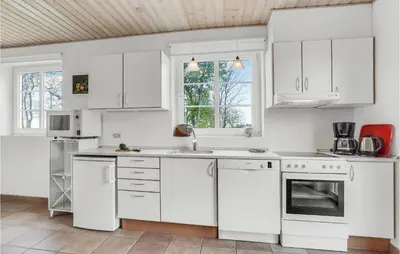 a white kitchen with white cabinets and appliances at 3 Bedroom Cozy Home In Vesløs in Vesløs