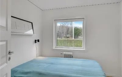 a white bedroom with a bed and a window at Cozy Home In Nykøbing M With Wifi in Refshammer
