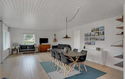 a dining room and living room with a table and chairs at Cozy Home In Nykøbing M With Wifi in Refshammer