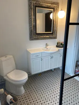a bathroom with a toilet and a sink and a mirror at 200 m til havet - fri adgang til svømmehal in Thyborøn