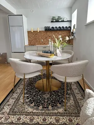 a dining room with a table and chairs on a rug at Skuespiller Centralen in Viborg