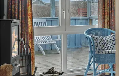 a blue chair sitting on a porch next to a window at 3 Bedroom Lovely Home In Lemvig in Lemvig