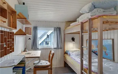 a dorm room with bunk beds and a desk and a desk at 3 Bedroom Lovely Home In Lemvig in Lemvig