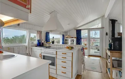 a kitchen with white counters and windows and a sink at 3 Bedroom Lovely Home In Lemvig in Lemvig