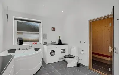 a bathroom with a tub and a toilet and a sink at Nice Home In Fur With Sauna in Furland
