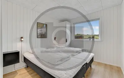 a bedroom with a large bed with a round mirror at 4 Bedroom Beautiful Home In Løgstrup in Løgstrup
