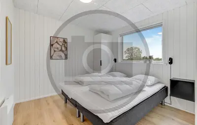 a bedroom with a large bed with a large window at 4 Bedroom Beautiful Home In Løgstrup in Løgstrup
