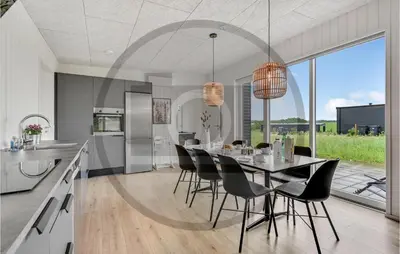 a kitchen and dining room with a table and chairs at 4 Bedroom Beautiful Home In Løgstrup in Løgstrup