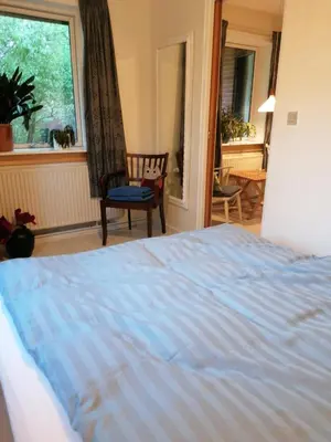 a bedroom with a bed and a window and a chair at B&B Tvolm Ydby Thy in Tvolm