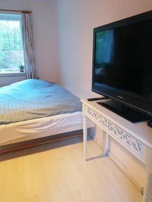 a bedroom with a television on a table with a bed at B&B Tvolm Ydby Thy in Tvolm