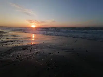 a sunset on a beach with the ocean at 4 person holiday home in Frøstrup in Frøstrup