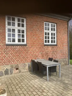 a table and chairs in front of a brick building at Store Sand in Vemb