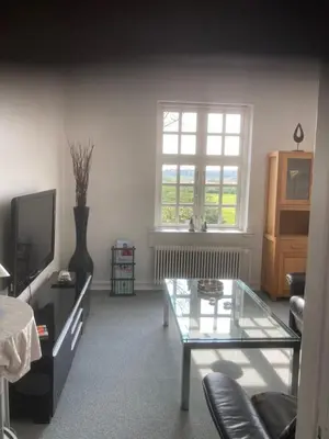 a living room with a tv and a glass table at Store Sand in Vemb